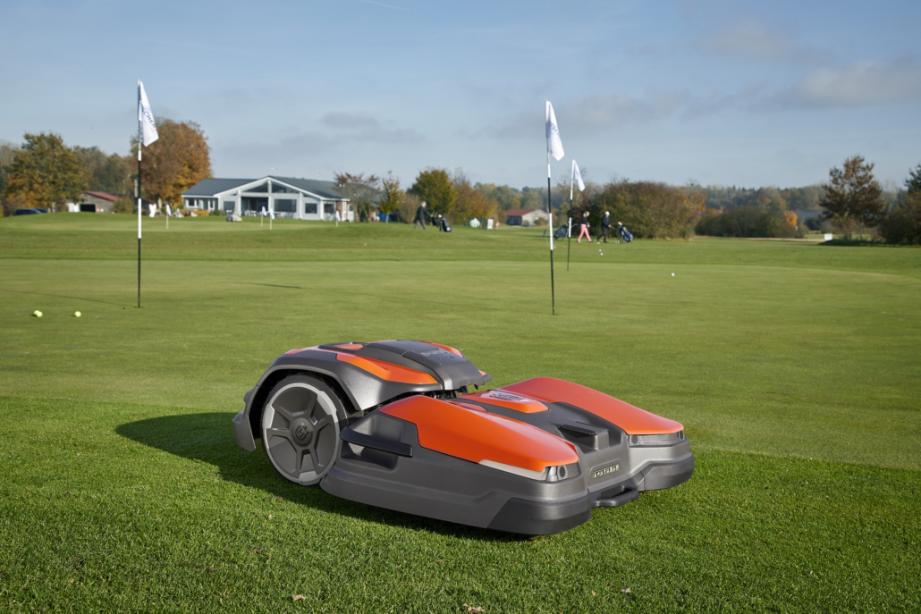 A Husqvarna CEORA mower is cutting the grass on a golf course.