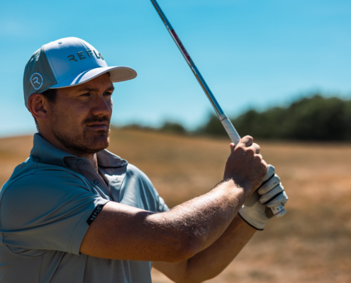 Golfspieler mit einem blauen Golfhemd, das nachhaltig hergestellt wurde.