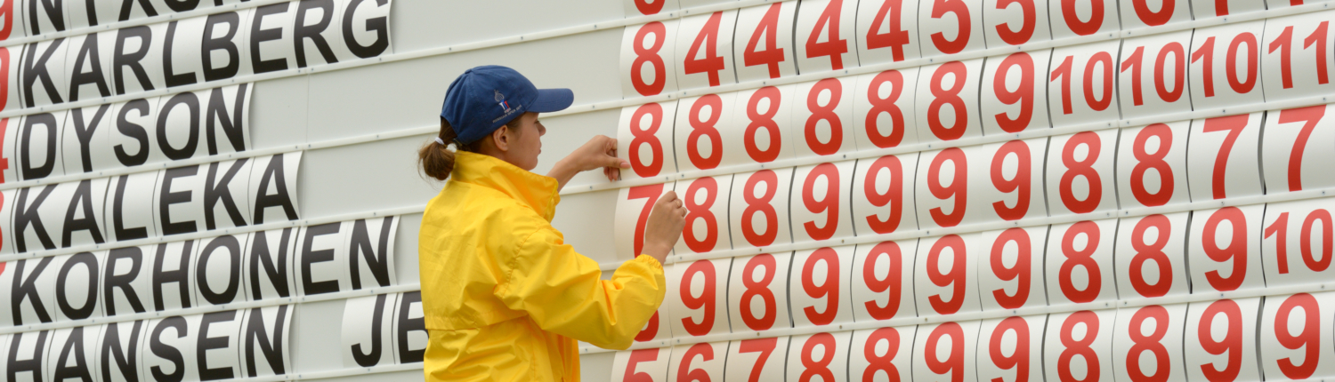 Mädchen fügt die genauen Loch-Ergebnisse beim Scoreboard eines Golf-Turniers ein.