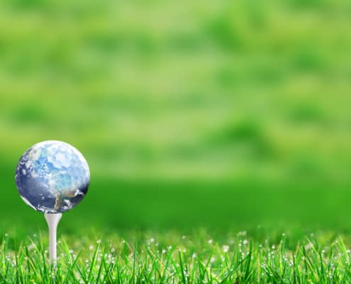 Ball im Design einer Weltkugel auf einem Tee des Golfplatzes
