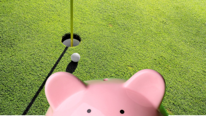 Ein Sparschwein vor einer Golfanlage
