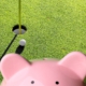 Ein Sparschwein vor einer Golfanlage